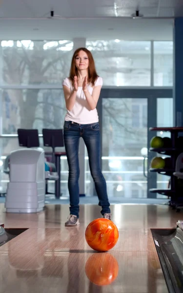 Boldog lány és a bowling golyó gurul a háttérben. — Stock Fotó