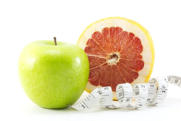 Apple, slice of grapefruit with tape measure Stock Photo