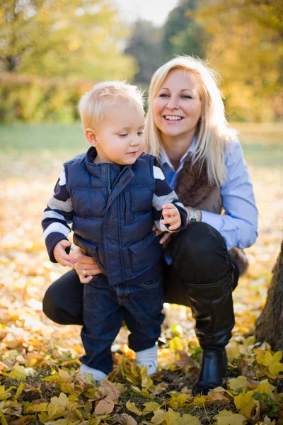 Cute kid and pretty mom outdoors at fall. — Stock Photo, Image