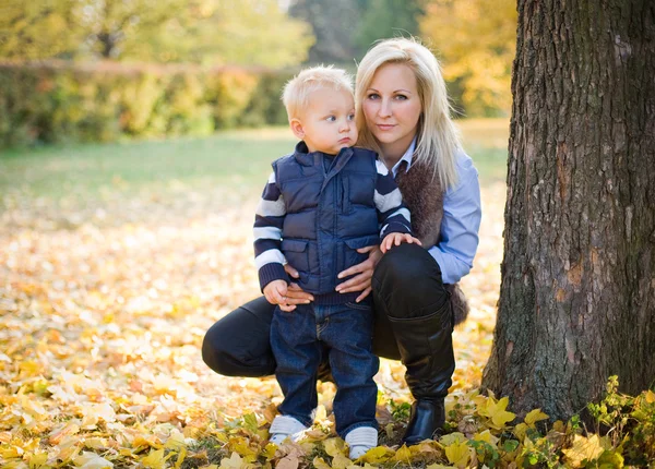 Ελκυστική νεαρή μητέρα με τον γιο της στο πάρκο. — Φωτογραφία Αρχείου