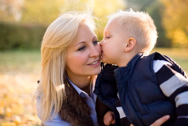 Aantrekkelijke jonge moeder met haar zoon in het park. — Stockfoto