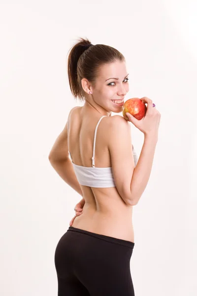 Μελαχρινή νεαρή γυμναστήριο με ζουμερός μήλο. — Φωτογραφία Αρχείου