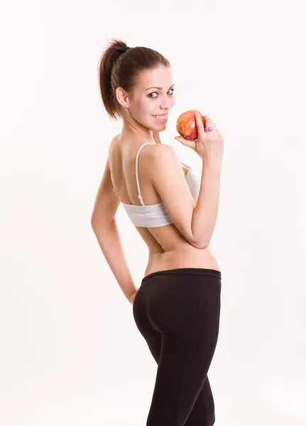 Niedliche Fitness-Brünette mit rotem Apfel. — Stockfoto