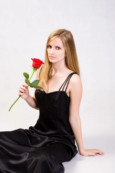 Ελκυστική νεαρή ξανθιά με φρέσκο τριαντάφυλλο. — Φωτογραφία Αρχείου