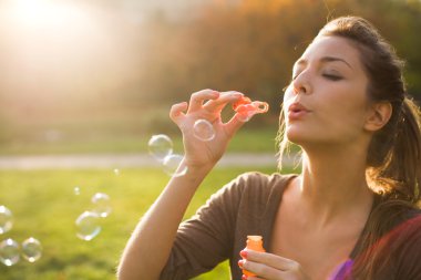 Blowing bubbles into the wind. clipart