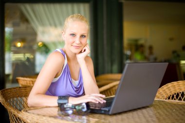 Beautiful young blond girl eith her laptop. clipart