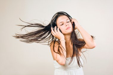 Gorgoeus young brunette immersed in music. clipart