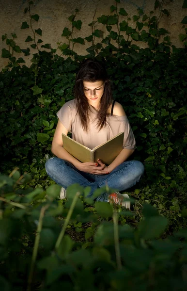 La magia de los libros. Hermosa morena yopung inmersa en readin — Foto de Stock