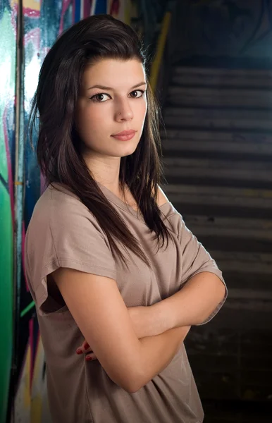 Stedelijke portret van een mooie jonge brunette meisje met graffiti b — Stockfoto