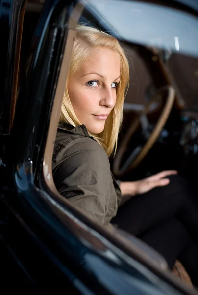 Ritratto di una bella giovane bionda in un'auto d'epoca . — Foto Stock