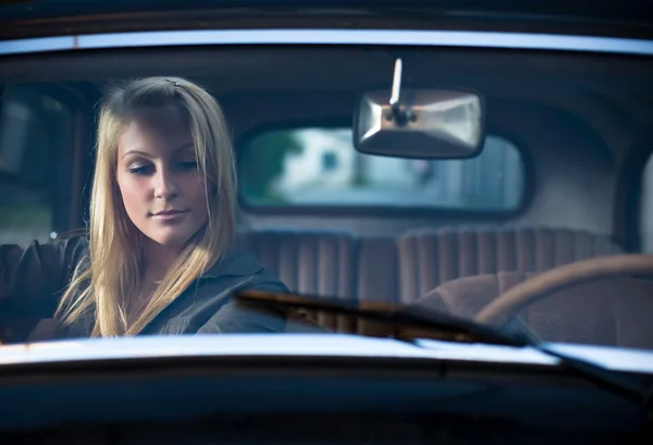 Güzel genç sarışın eski model bir araba içinde portresi. — Stok fotoğraf