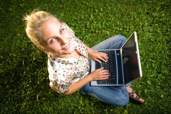 Gyönyörű, fiatal szőke birtoklás móka-val laptop a szabadban — Stock Fotó