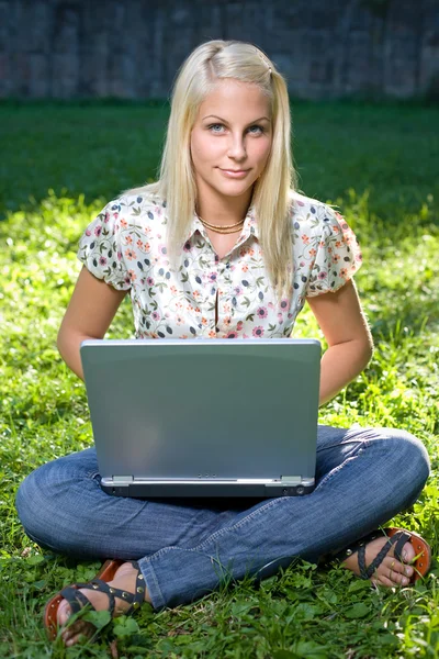 Splendida giovane bionda divertirsi con il computer portatile all'aperto — Foto Stock