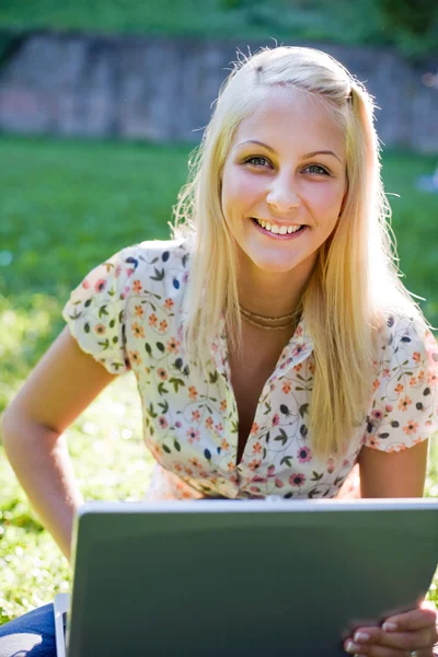 Underbara ung blond har roligt med laptop utomhus — Stockfoto