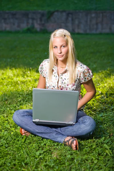 Menina loira muito jovem com laptop no parque . — Fotografia de Stock
