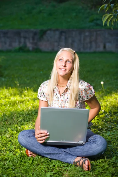 Hermosa rubia joven que se divierte con el ordenador portátil al aire libre —  Fotos de Stock