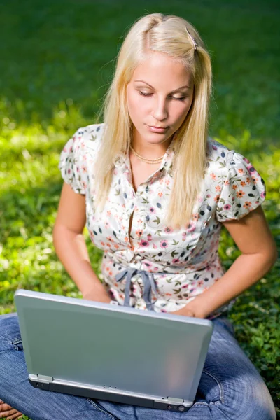 Cute young blond having fun with laptop outdoors. — Stock Photo, Image