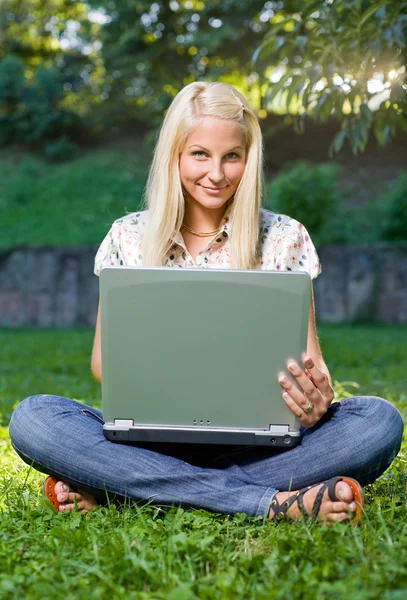 Menina loira muito jovem com laptop no parque . — Fotografia de Stock