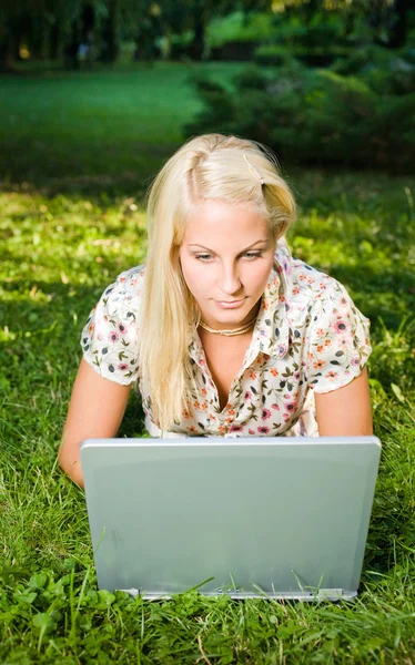 Όμορφη νεαρή ξανθιά χρησιμοποιώντας φορητό υπολογιστή σε εξωτερικούς χώρους. — Φωτογραφία Αρχείου