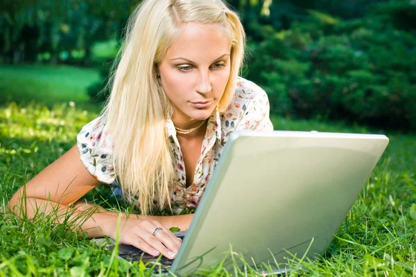 Underbara ung blond har roligt med laptop utomhus — Stockfoto