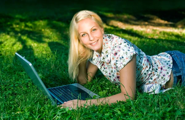 Όμορφη νεαρή ξανθιά χρησιμοποιώντας φορητό υπολογιστή σε εξωτερικούς χώρους στη φύση. — Φωτογραφία Αρχείου