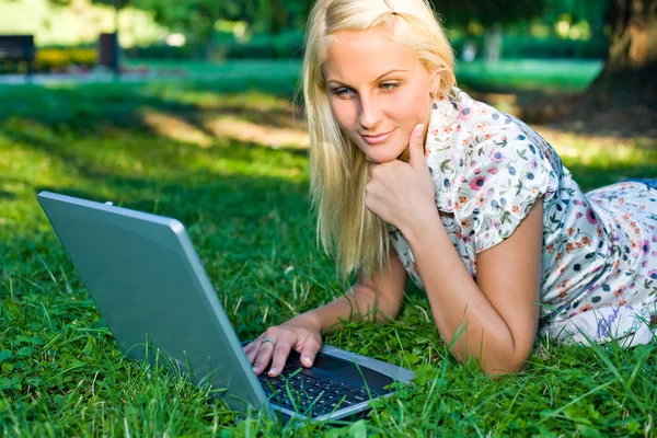 Vacker ung blond med laptop utomhus i naturen. — Stockfoto