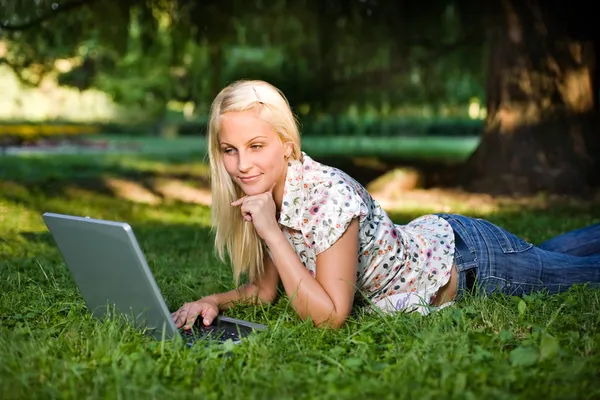 Vacker ung blond med laptop utomhus i naturen. — Stockfoto