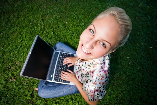 Πανέμορφη νεαρή ξανθιά διασκεδάζοντας με τον φορητό υπολογιστή σε εξωτερικούς χώρους — Φωτογραφία Αρχείου