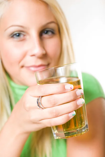 Красива молода блондинка тримає склянку яблучного соку, фокус — стокове фото