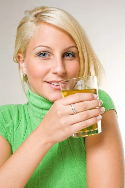Mooie jonge blonde meisje houdt van een glas appelsap, focu — Stockfoto