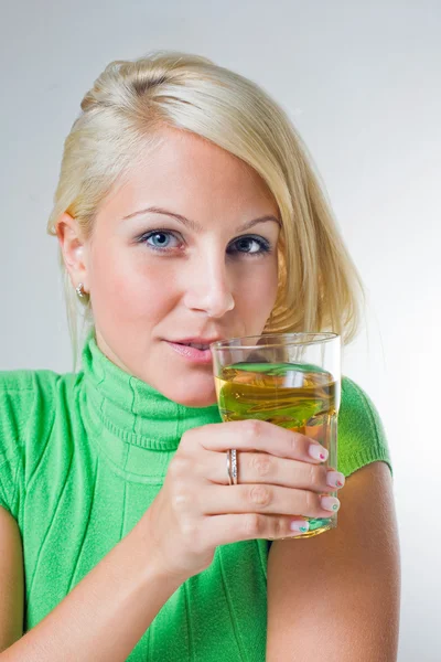 Bella ragazza bionda che tiene un bicchiere di succo di mela, focu — Foto Stock