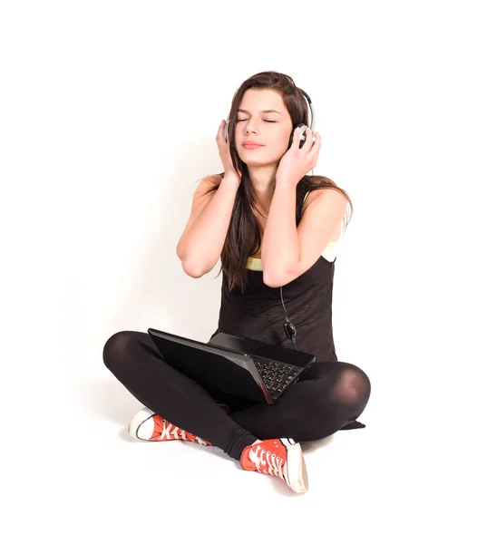 Splendida giovane bruna che ascolta musica usando il computer portatile . — Foto Stock