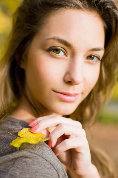 Podzimní park a krásná brunetka. — Stock fotografie
