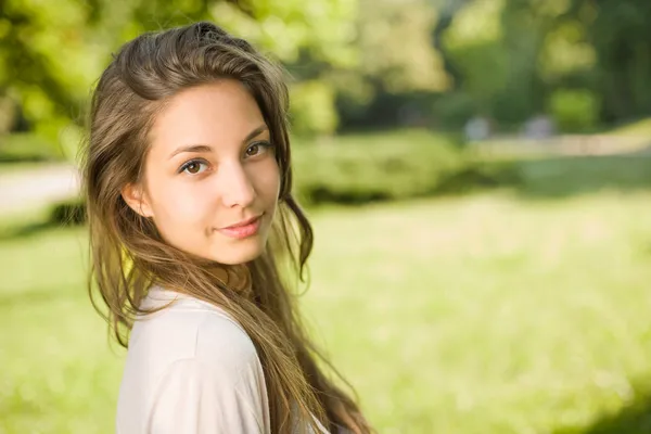 Prachtige jonge brunette in het park. — Stockfoto