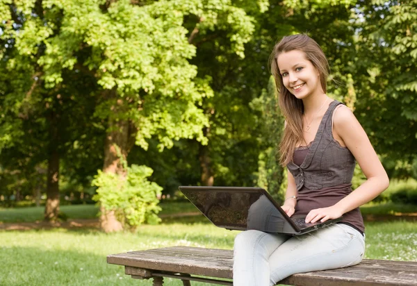 Söt ung tonåring användning latop utomhus. — Stockfoto