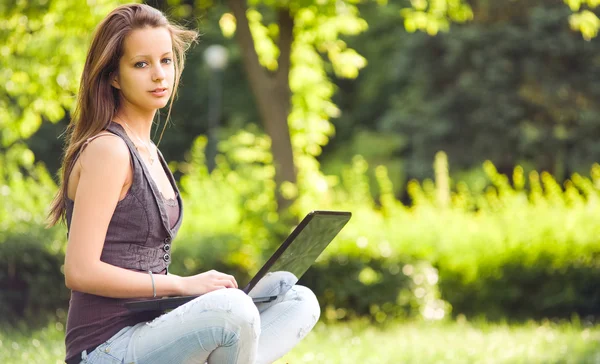 Young brunette girl with her latop. — Stock Photo, Image