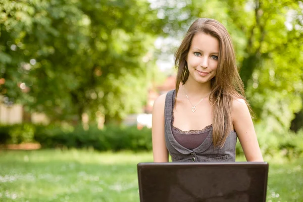 Lindo joven adolescente usando latop al aire libre . — Foto de Stock