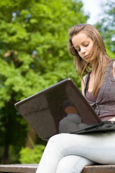 Ung student med hennes laptop utomhus. — Stockfoto