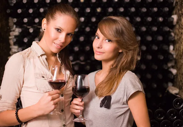 Två vackra brunetter smaka vin. — Stockfoto