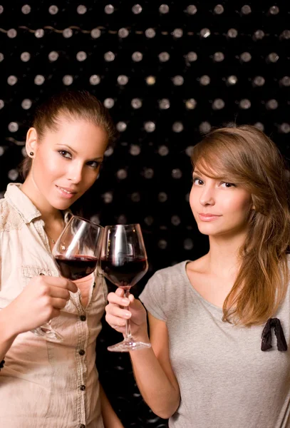 Två vackra brunetter smaka vin. — Stockfoto