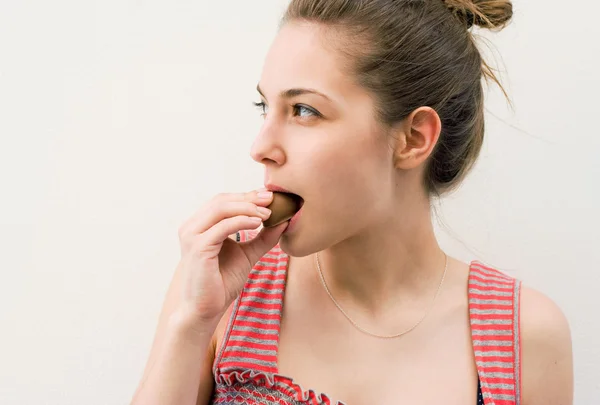 Beautiful young brunette having chocolate snack. — Stock Photo, Image