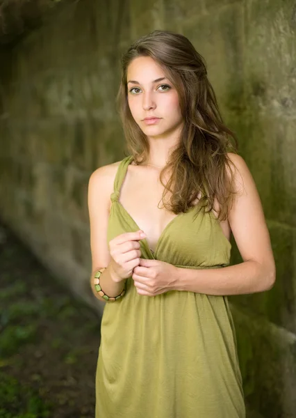 Beautiful young brunette posing in green dress. — Stock Photo, Image