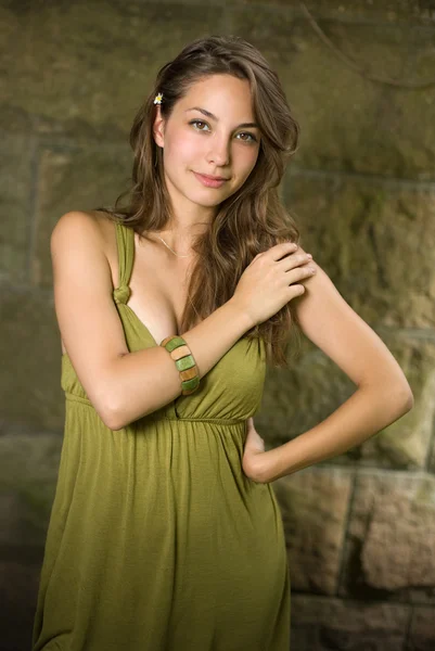 Mooie jonge brunette poseren in groene jurk. — Stockfoto