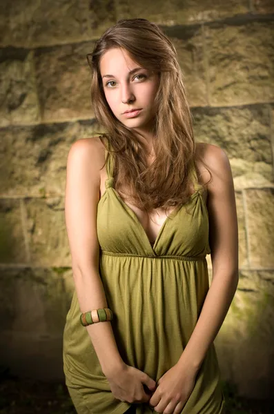 Όμορφη νεαρή μελαχρινή που θέτουν σε πράσινο φόρεμα. — Φωτογραφία Αρχείου