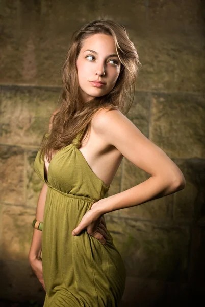 Όμορφη νεαρή μελαχρινή που θέτουν σε πράσινο φόρεμα. — Φωτογραφία Αρχείου