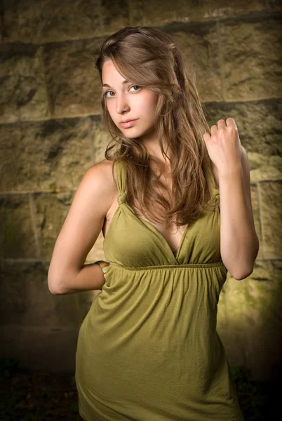 녹색 드레스를 입고 포즈를 취하는 아름 다운 젊은 갈색 머리. — 스톡 사진