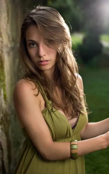 Mooie jonge brunette poseren in groene jurk. — Stockfoto