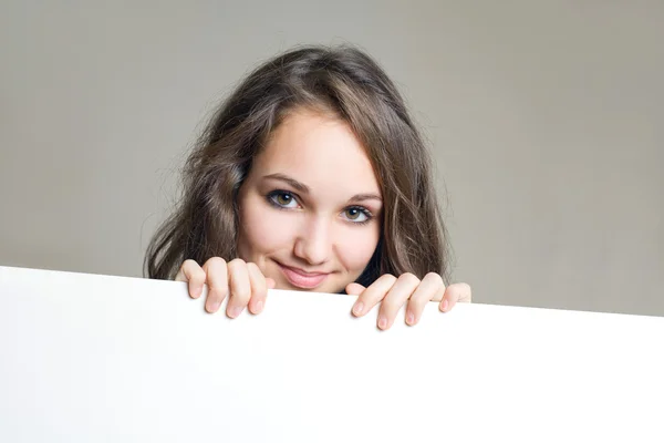 Lachende jonge brunette meisje met lege witte bord. — Stockfoto