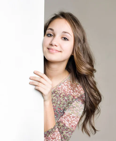 Sorridente giovane ragazza bruna con segno bianco vuoto . — Foto Stock