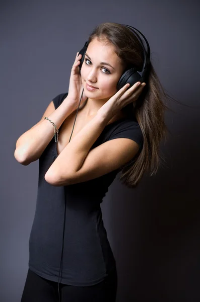 Prachtige jonge brunette luisteren naar muziek. — Stockfoto